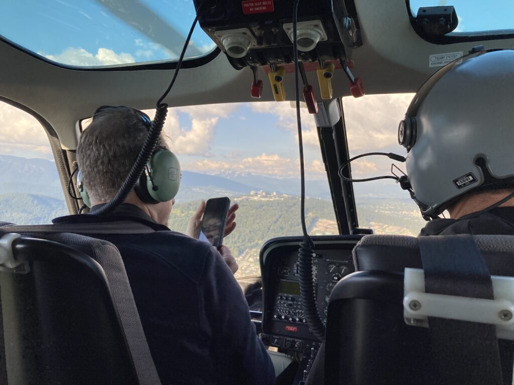 Photographer sitting next to helicopter pilot